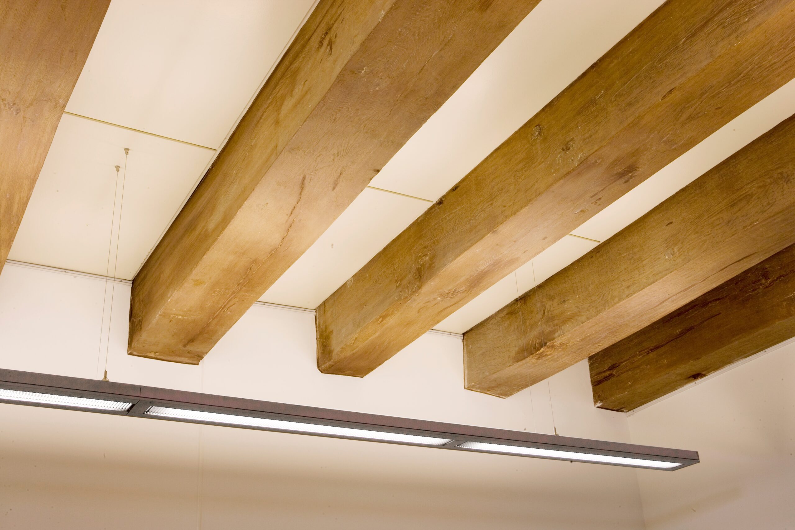 Wooden,Beams,And,Light,Fixture,At,Ceiling,In,Historical,House.